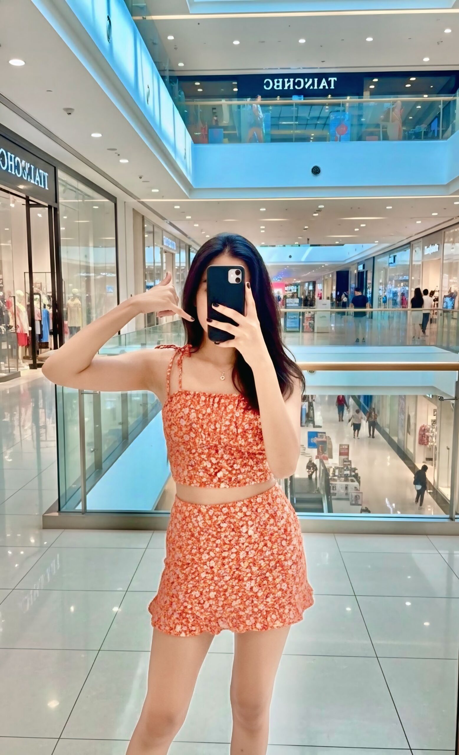 Young stylish woman taking mirror selfie in modern shopping mall in Mohali